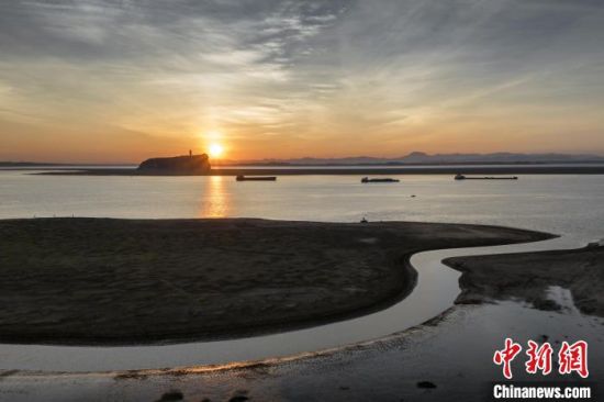 8月13日，航拍位于江西省九江市湖口縣境內的鄱陽湖鞋山島日出， 灘涂被湖水沖刷形成了一道道弧線。祝興勇 攝