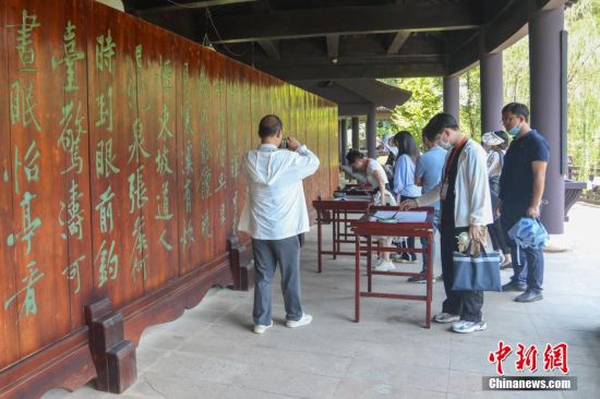  图为游客在双井村的进士园内体验书法艺术。刘力鑫 摄