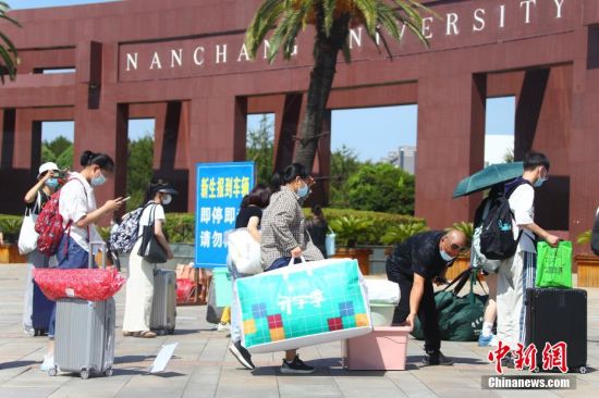 6 圖為南昌大學2022級新生及新生家長提著行李在南昌大學正門口排隊。 劉占昆 攝