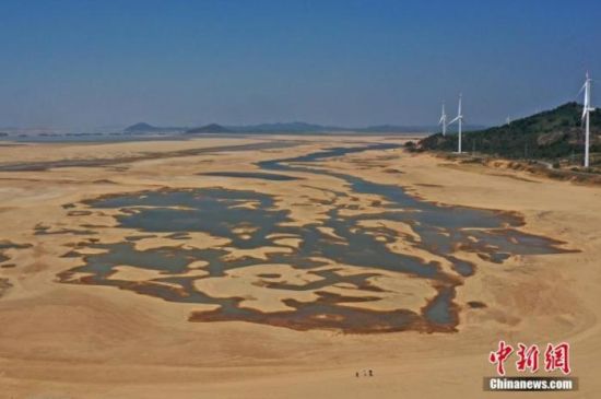 在江西省九江市都昌县鄱阳湖水域，干涸的湖床形成多个大小不同的水洼，几名游客正在滩涂上行走。(资料图) 刘占昆 　摄