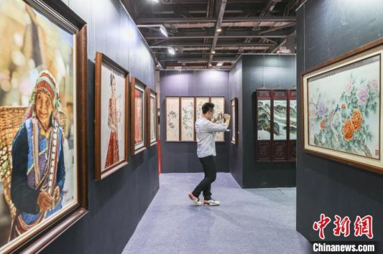 5圖為參觀者在拍攝展出的“國家級非物質文化遺產”南昌瓷板畫作品�！⒘� 攝