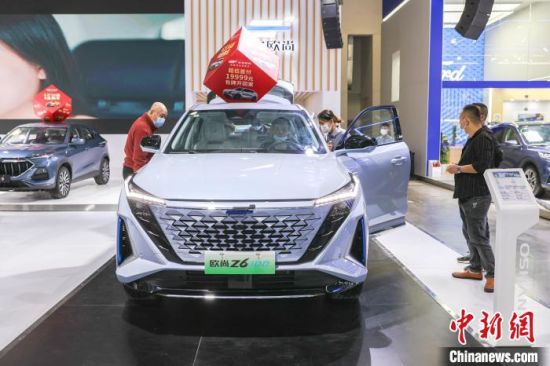 3 圖為2022第十七屆南昌國際汽車展現場，幾位市民在觀看和體驗一輛新能源汽車�！⒘� 攝