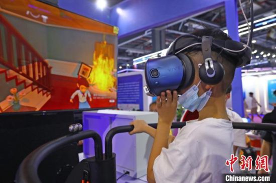 2 图为一名男童戴着VR眼镜体验火灾逃生现场知识教学。　刘占昆 摄