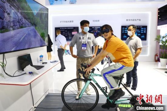 8图为一名女子戴着VR眼镜正在体验骑行公路自行车。　刘占昆 摄