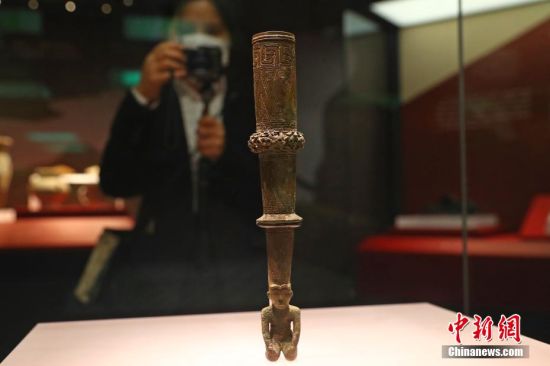 5图为一名观众正在拍摄江西樟树国字山墓葬中出土的青铜鸠杖跽坐人镦。 刘占昆 摄