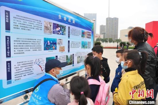 圖為2022年度江西省古生物化石保護利用科普宣傳活動南昌分會場，志愿者在給幾位小朋友講解科普知識�！⒘� 攝
