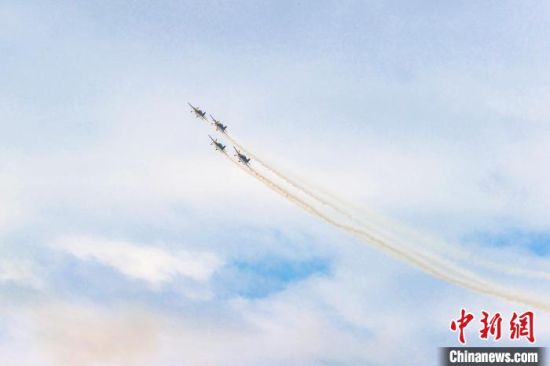 圖為特技飛機編隊在藍天白云之下進行拉煙編隊飛行表演�！⒘� 攝