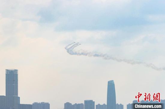 圖為特技飛機編隊在贛江南昌主城區段的上空進行拉煙編隊飛行表演�！⒘� 攝