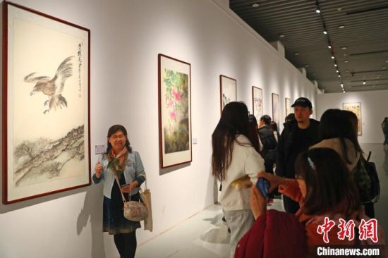 11月15日，一名臺灣畫家與自己展出的書畫作品合影。劉占昆 攝