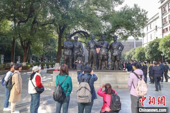 图为游客在南昌八一起义纪念馆的《一代英豪》雕塑前拍照留念。刘力鑫 摄