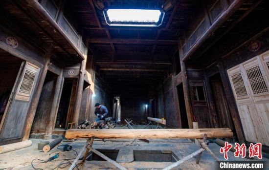 12月21日，江西省新余市渝水区新溪乡西江村修缮古建筑，这是工人在制作门板。赵春亮 摄