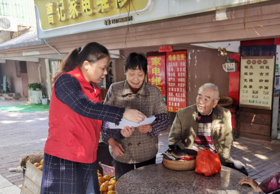 图为吉安市烟草专卖局党员志愿者向社区老人进行普法宣传