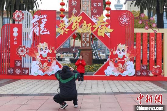 图为江西南昌八一广场，小朋友在龙年春节主题装饰前拍照。刘力鑫 摄