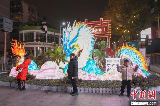 图为江西南昌万寿宫历史文化街区，民众在龙年主题灯饰前拍照。刘力鑫 摄