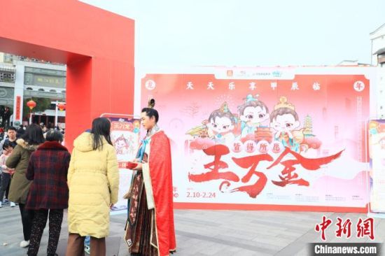 图为春节假期，南昌旅游IP形象“王万金”正在与游客互动。刘思伟 摄