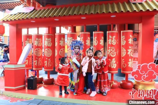 图为春节期间，在江西南昌绳金塔历史文化街区，身着传统戏曲服饰的工作人员与小游客互动。刘思伟 摄