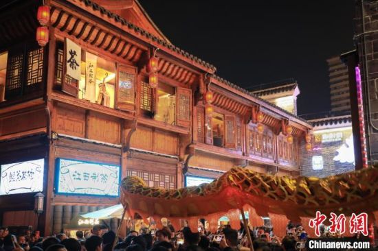 2月11日，江西省南昌市万寿宫历史文化街区的一家茶饮店的中国传统乐器演奏吸引了不少游客驻足。　刘思伟 摄
