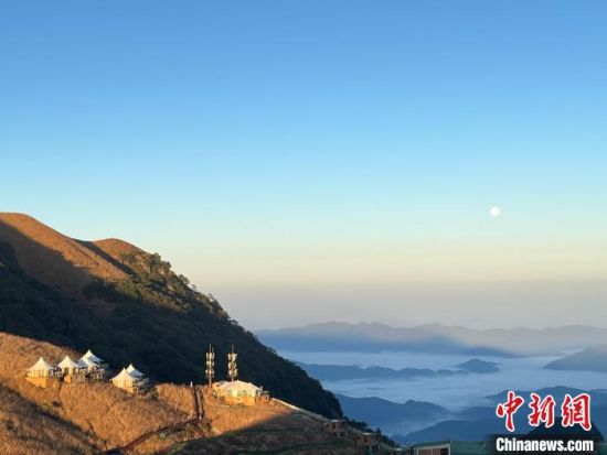 2023年11月28日，初冬时节的江西省萍乡武功山云海翻滚，　朝阳的光芒透过薄薄的晨雾洒向远方的山峦。　王剑摄