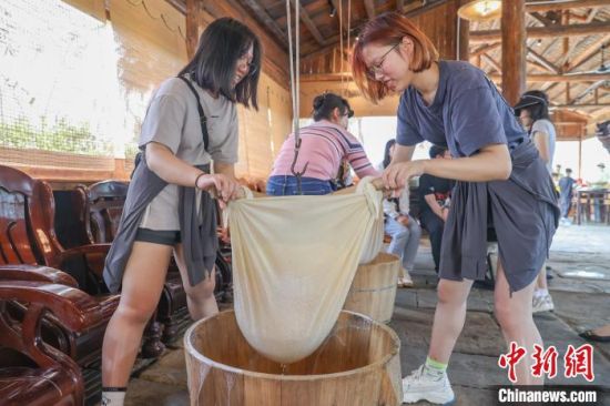 图为香港青年在体验用传统工具过滤豆浆。刘力鑫 摄