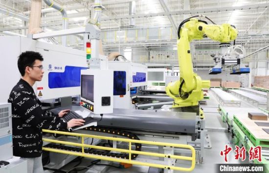 在江西赣州市南康区共享智能备料中心，工人操作着智能机械臂生产家具备料。(资料图)杨晓明摄