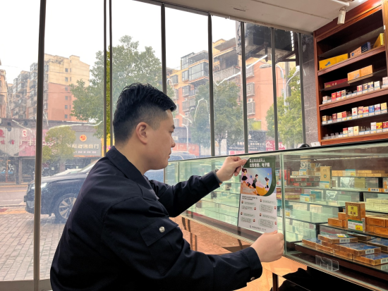 弋阳县烟草局工作人员在校园周边零售店张贴未成年人保护宣传海报
